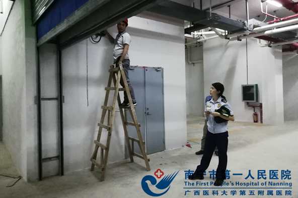 图为消防人员在检测防火卷帘门的升降情况.jpg
