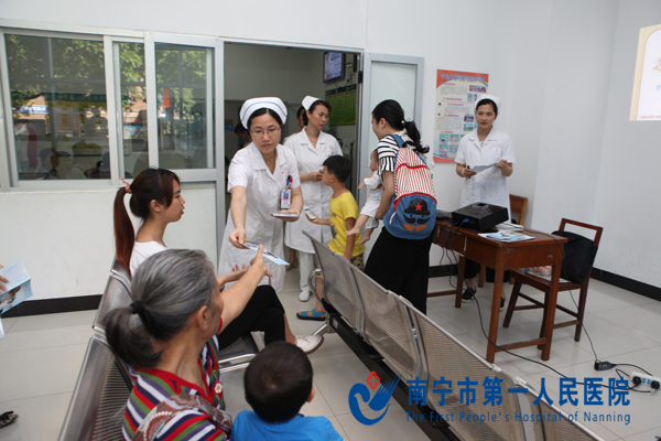 护士给家长们发放手足口病宣传册.jpg
