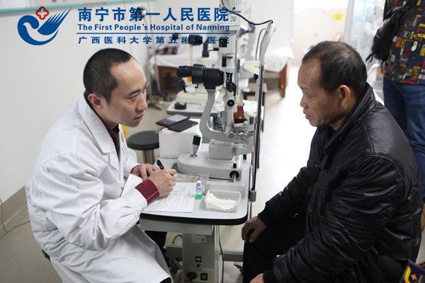 图为:南宁市第一人民医院眼科主任凌宇正在为贫困户蓝忠明检查.JPG