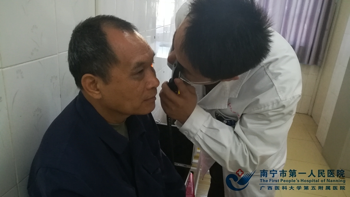 3.我院眼科梁海明医生给贫困户检查眼底.jpg