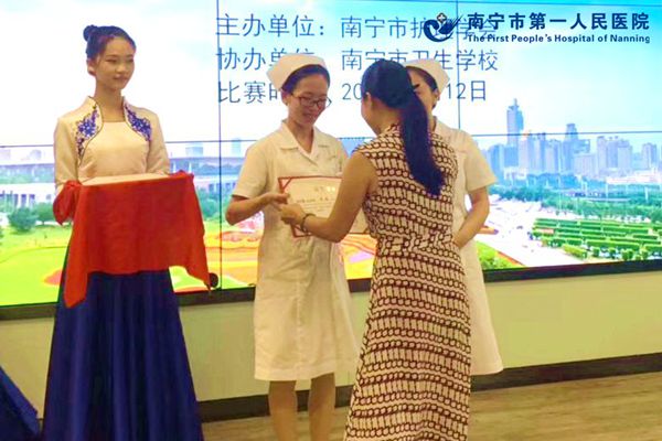 2.图为梁潘从南宁市卫生学校郑校长手中领取奖状.jpg