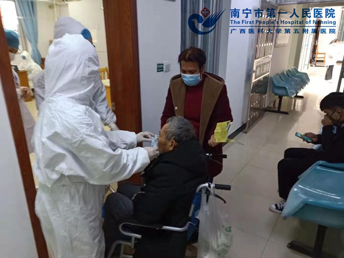 1580954641222066905.jpg 发热门诊护士为患者佩带口罩.jpg