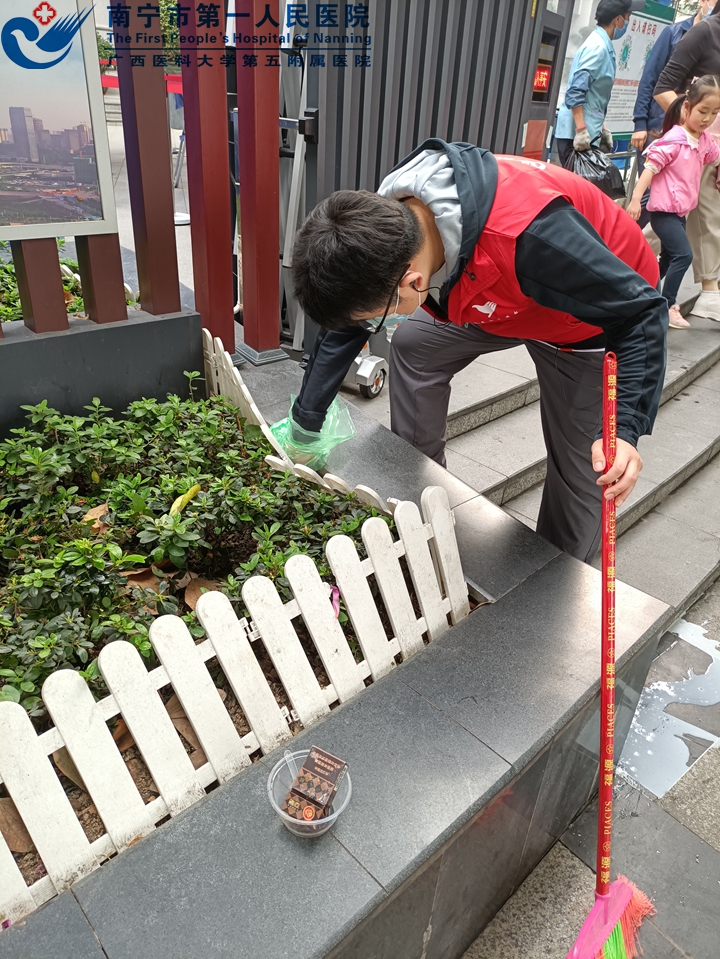 1617094513779031141.jpg 1图为住培支部党员在清理花圃中的烟头-陆新凤供图.jpg