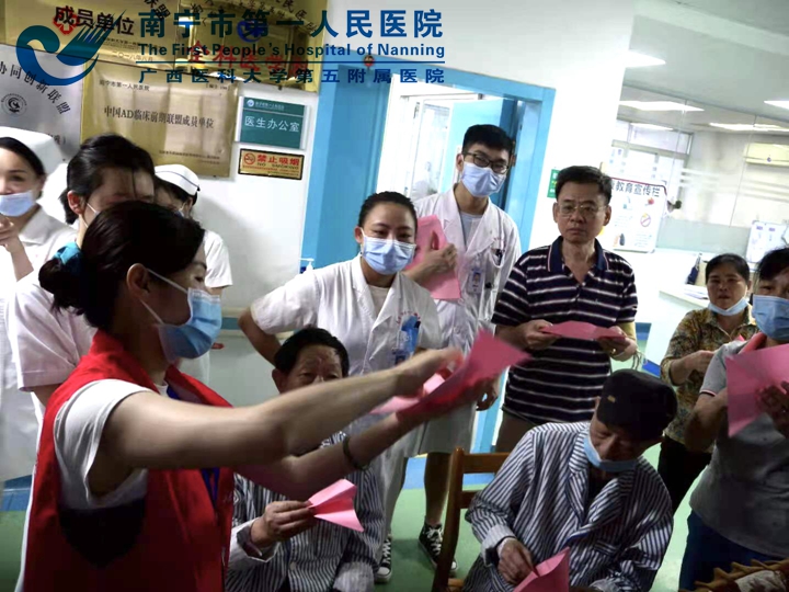 1623050661816084126.jpg 图为小乐园志愿者手把手教老人折玫瑰花.jpg