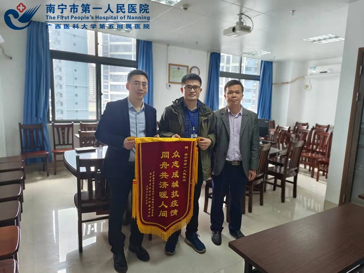1646357522608075569.jpg 青秀区中山街道党工委副书记、办事处主任刘东东(左一),七星社区党委书记、居委会主任施文杰(右一)向我院赠送锦旗1.jpg